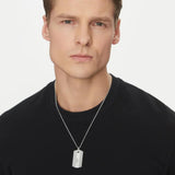 Ανδρικό κολιέ Emporio Armani EGS3149040 ατσάλινο ασημί με κρεμαστό μοτίφ ταυτότητα σε ασημί χρώμα και ανάγλυφες λεπτομέρειες, φορεμένο.