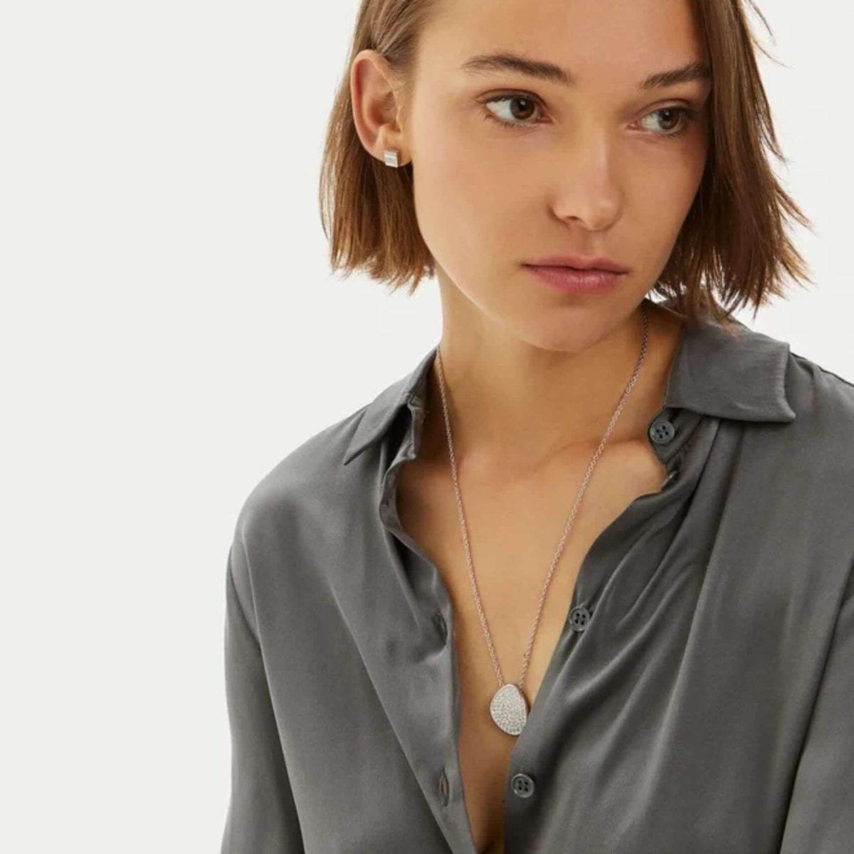 Γυναικείο κολιέ Calvin Klein 35000222 ατσάλινο σε ασημί χρώμα διακοσμημένο με λευκά ζιργκόν, φορεμένο.