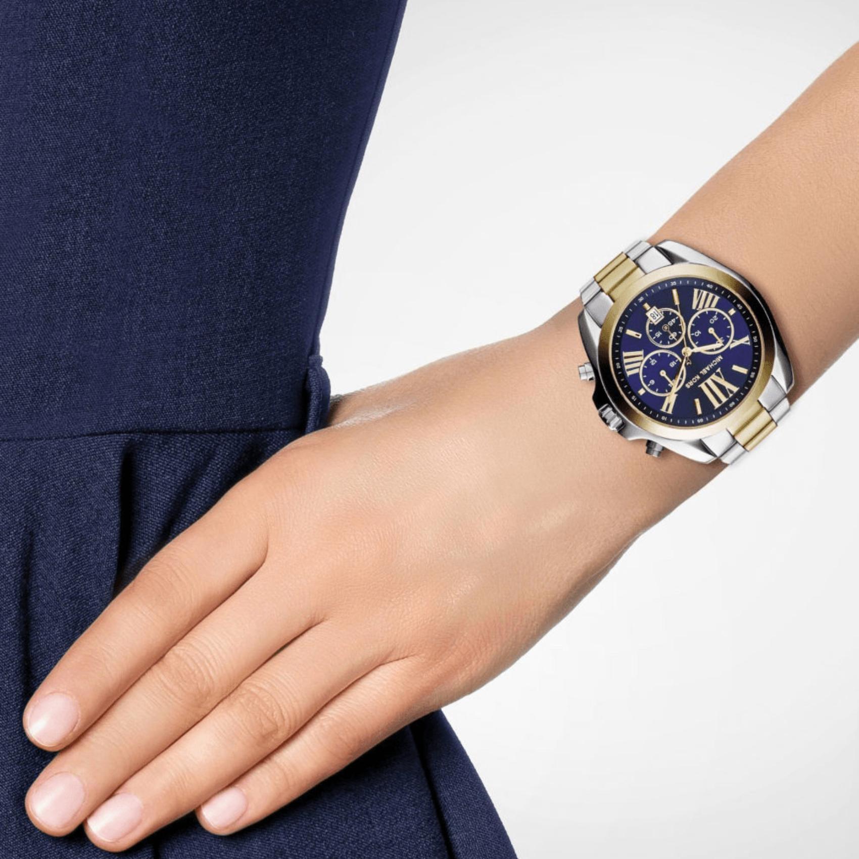 Γυναικείο ρολόι Michael Kors Bradshaw MK5976 χρονογράφος με δίχρωμο ατσάλινο μπρασελέ σε χρυσό-ασημί χρώμα, στρογγυλό μπλε καντράν με ημερομηνία και στεφάνι 42mm.