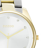Ρολόι Oozoo C10960 με ασημί-χρυσό ατσάλινο μπρασελέ, ασημί καντράν διαμέτρου 36mm με ζιργκόν και μηχανισμό μπαταρίας quartz.