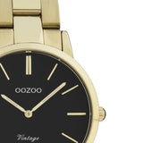 Ρολόι Oozoo Vintage C20047 με χρυσό ατσάλινο μπρασελέ,μαύρο κανράν, στρογγυλό στεφάνι διαμέτρου 34mm και μηχανισμό μπαταρίας quartz.