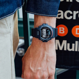 Ψηφιακό ρολόι Casio G-SHOCK DW-6900U-1ER με μαύρο καουτσούκ λουράκι και ψηφιακό καντράν  54,9mm-φορεμένο.