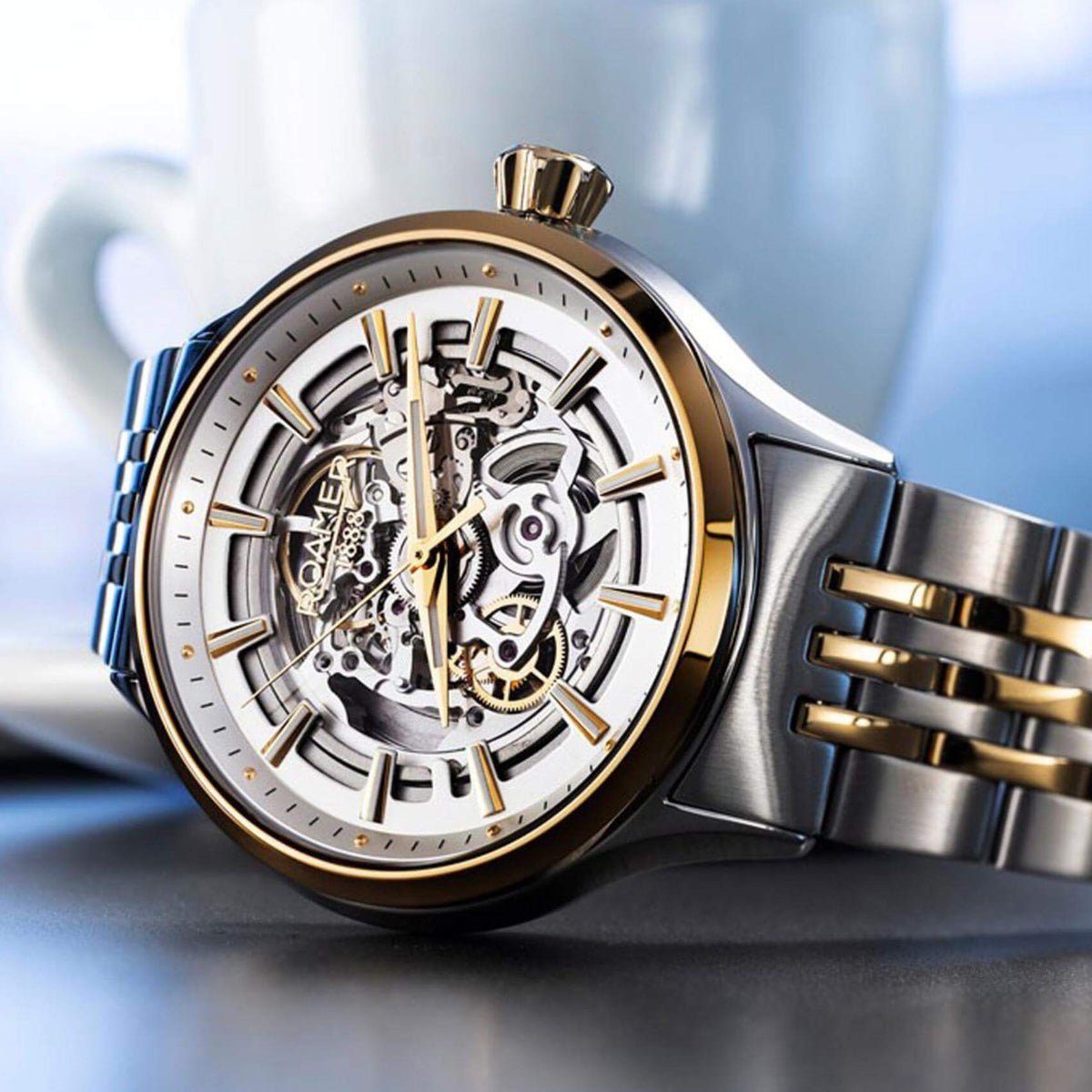 Αυτόματο Ρολόι Skeleton Roamer Competence III 101663-47-15-10 με  δίχρωμο ασημί-χρυσό ατσάλινο μπρασελέ διάφανο ασημί καντράν, τζαμάκι από ζαφείρι και στεφάνι διαμέτρου 43mm.