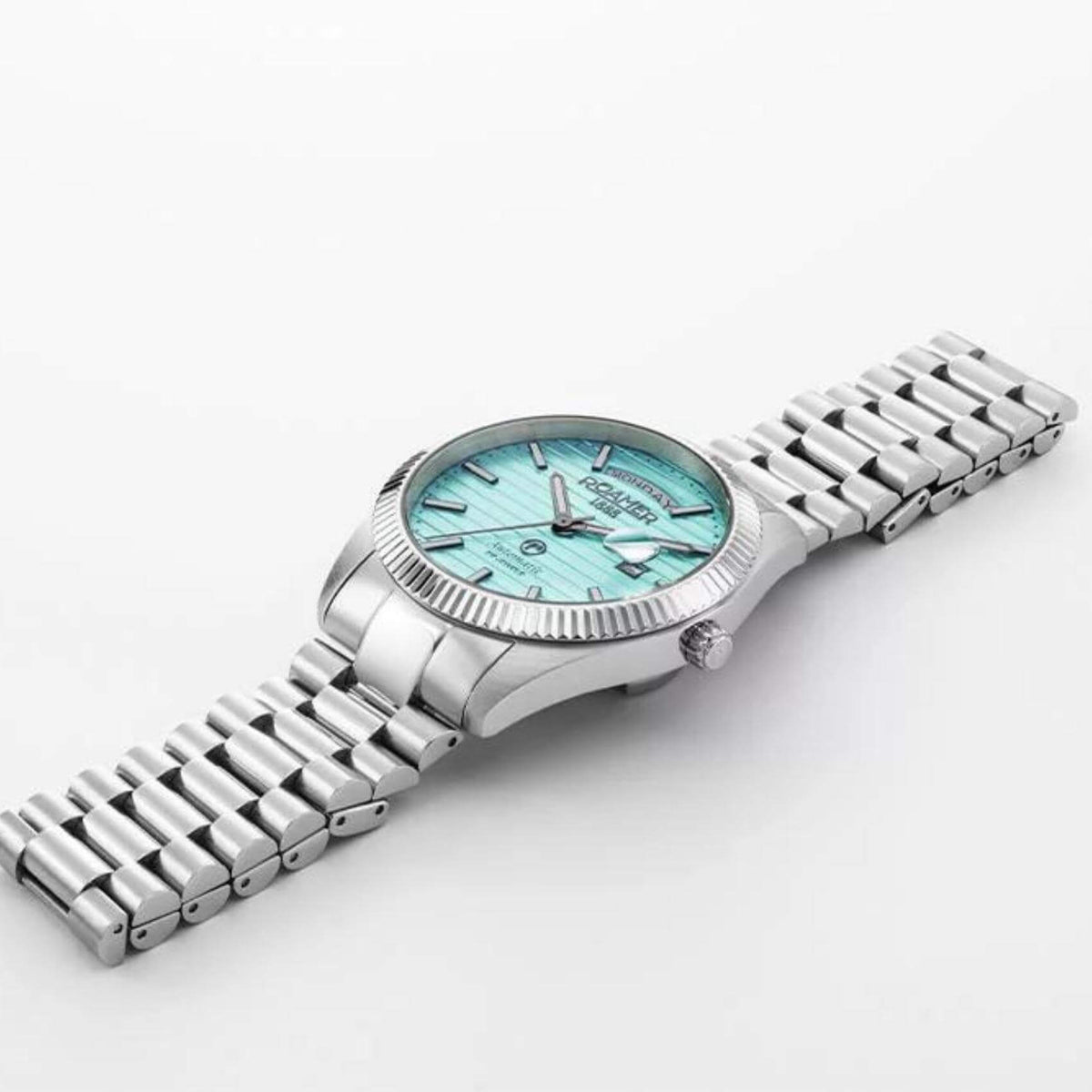 Αυτόματο ρολόι open back Roamer Primeline Day Date II 981666-41-05-50 με ασημί μπρασελέ, γαλάζιο καντράν με ένδειξη ημέρας και ημερομηνίας και κάσα διαμέτρου 42mm.