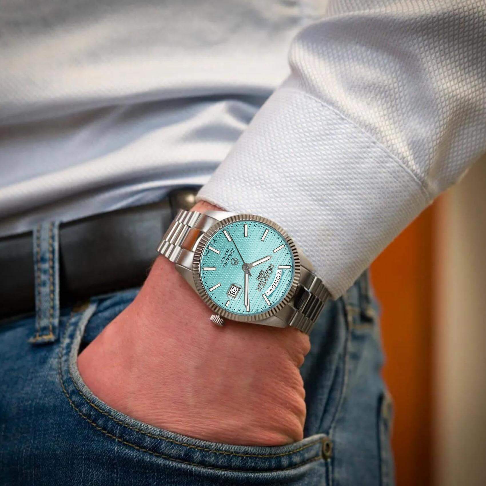 Αυτόματο ρολόι open back Roamer Primeline Day Date II 981666-41-05-50 με ασημί μπρασελέ, γαλάζιο καντράν με ένδειξη ημέρας και ημερομηνίας και κάσα διαμέτρου 42mm.