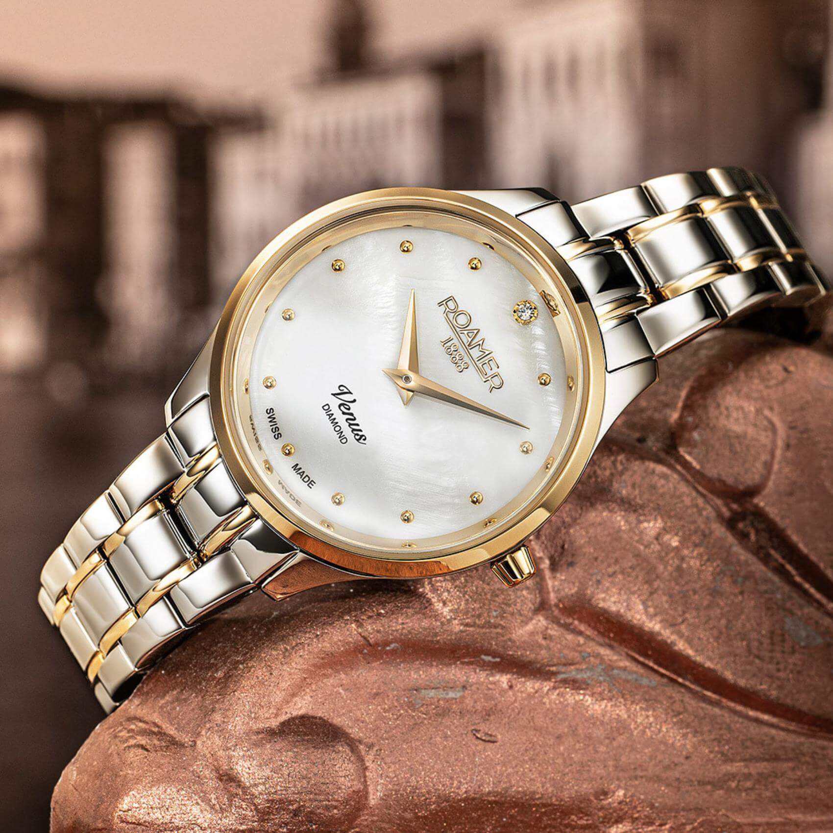 Ρολόι Roamer Venus Diamonds 601857-47-89-20 με δίχρωμο ασημί-χρυσό ατσάλινο μπρασελέ, άσπρο φίλντισι καντράν με διαμάντια, μηχανισμό μπαταρίας quartz, τζαμάκι από ζαφείρι και στεφάνι διαμέτρου 30mm.
