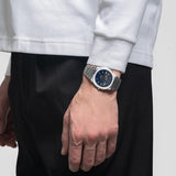 Ρολόι D1 Milano Carbon Reef D1-UHBJ04 σε ανδρικό χέρι με ασημί ατσάλινο μπρασελέ.
