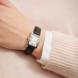 Γυναικείο ρολόι Gant Rhode Island Mini G195005 με μαύρο δερμάτινο λουράκι και άσπρο τετράγωνο καντράν μεγέθους 20,5mm, φορεμένο.