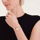 Rosefield Bangle S STWGSG-ST04 σε γυναικείο χέρι με χρυσό ατσάλινο μπρασελέ.