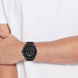 Ανδρικό ρολόι Tommy Hilfiger Morgan 1710690 με μαύρο ατσάλινο μπρασελέ και μαύρο καντράν διαμέτρου 48mm, φορεμένο.