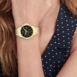Γυναικείο ρολόι Tommy Hilfiger Arianna 1782504 με χρυσό ατσάλινο μπρασελέ και μαύρο καντράν διαμέτρου 38mm με ζιργκόν.