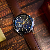 Ανδρικό ρολόι Tommy Hilfiger Owen 1791965 με καφέ δερμάτινο λουράκι και μπλε καντράν διαμέτρου 46mm με ένδειξη ημέρας-ημερομηνίας.