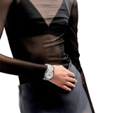 Ρολόι D1 Milano D1-NYBJ01 φορεμένο σε γυναικείο καρπό, με διαφανές λουράκι nylon και λευκό καντράν Ø39 mm.