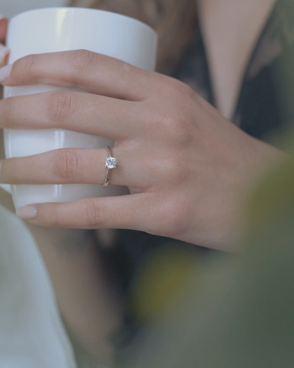 Λευκόχρυσο μονόπετρο με διαμάντι σε καστόνι σχήματος "V" και λεπτομέρεια καρδιάς φορεμένο σε γυναικείο χέρι.