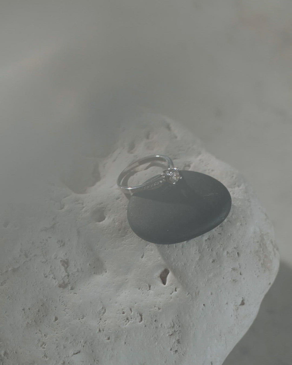 Μονόπετρο δαχτυλίδι λευκόχρυσο Κ14 με πλαϊνές πέτρες.