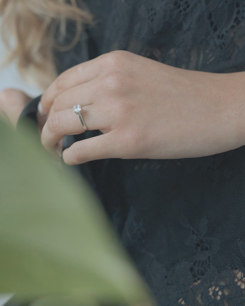 Λευκόχρυσο μονόπετρο με διαμάντι και καστόνι σε σχήμα "V" φορεμένο σε γυναικείο χέρι. 