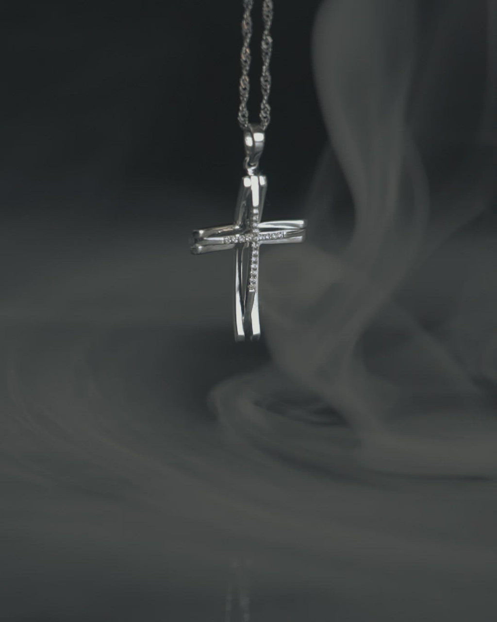 Γυναικείος σταυρός από λευκόχρυσο Κ18 με διαμάντια, περασμένος σε στριφτή αλυσίδα. 