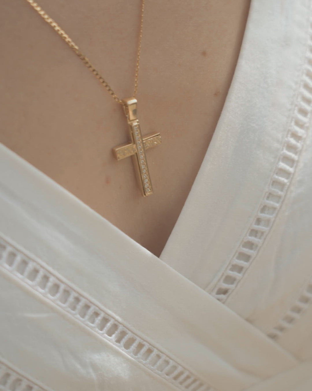 Χειροποίητος βαπτιστικός σταυρός από χρυσό Κ14 για κορίτσι. Μοντέρνο σχέδιο με ζιργκόν. Φορεμένος σε μοντέλο.