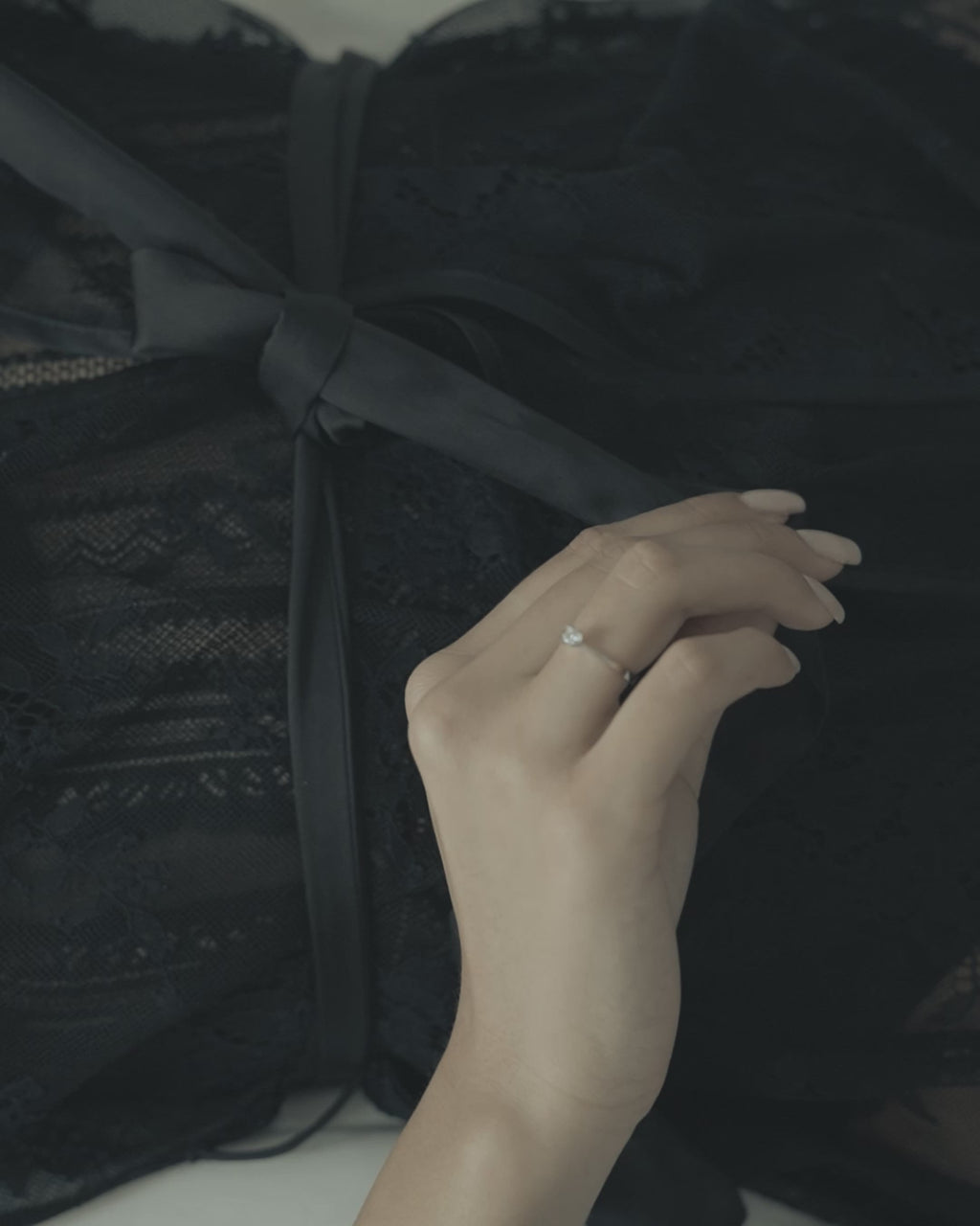 Λευκόχρυσο μονόπετρο με διαμάντι και καστόνι σε σχήμα "V" φορεμένο σε γυναικείο χέρι.
