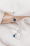 Λευκόχρυσα σκουλαρίκια κρεμαστά Κ14 με μπλε τοπάζ πέτρα