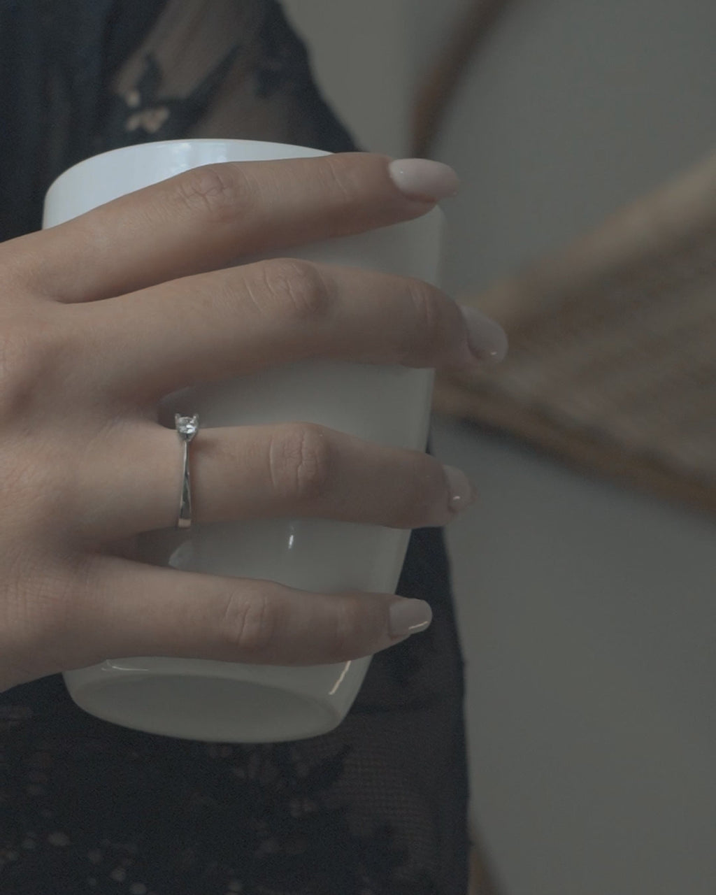 Λευκόχρυσο μονόπετρο με διαμάντι και καστόνι σχήματος V φορεμένο σε γυναικείο χέρι..