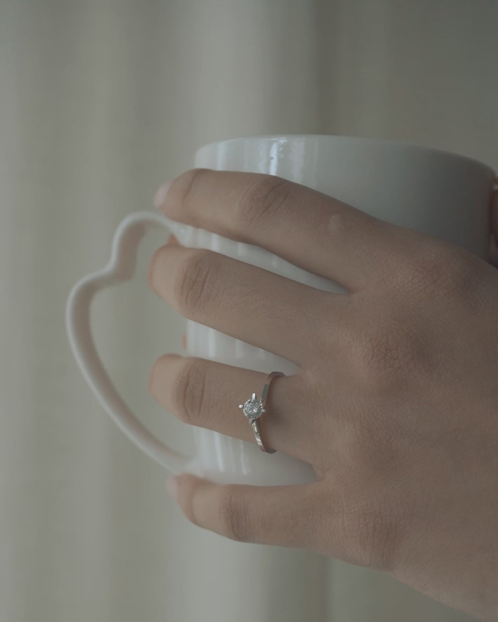 Λευκόχρυσο μονόπετρο δαχτυλίδι με διαμάντι φορεμένο σε γυναικείο χέρι. 