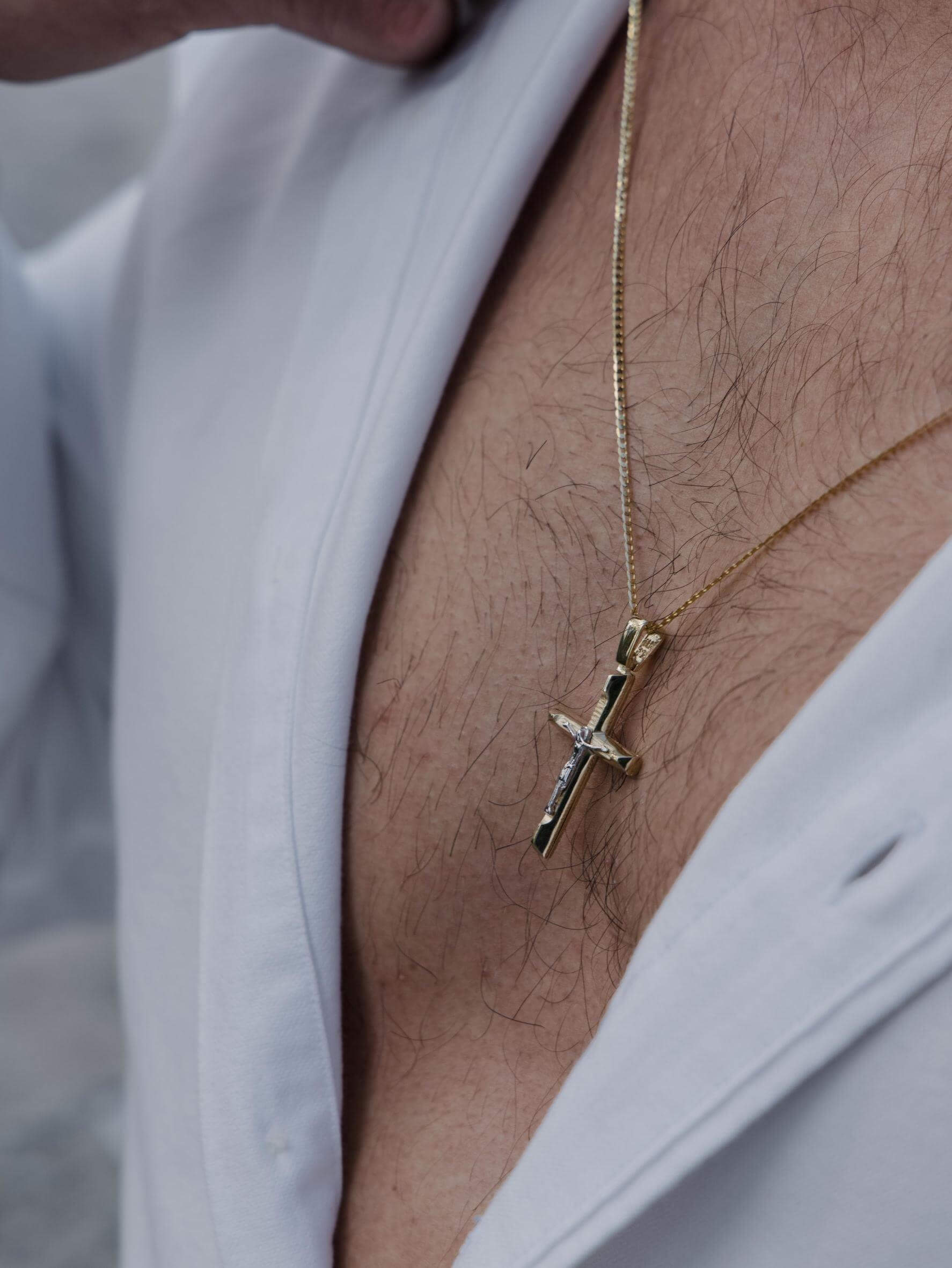 Ανδρικός βαπτιστικός σταυρός MCS057 από χρυσό 14Κ διπλής όψεως με ανάγλυφη όψη και Εσταυρωμένο, φορεμένος.
