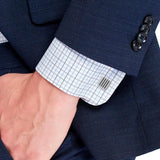 Ανδρικά μανικετόκουμπα Tommy Hilfiger σε ασημένιο χρώμα με χαραγμένες ρίγες και τετράγωνο σχήμα, κατασκευασμένα από χειρουργικό ατσάλι φορεμένα με πουκάμισο σε ανδρικό χέρι.
