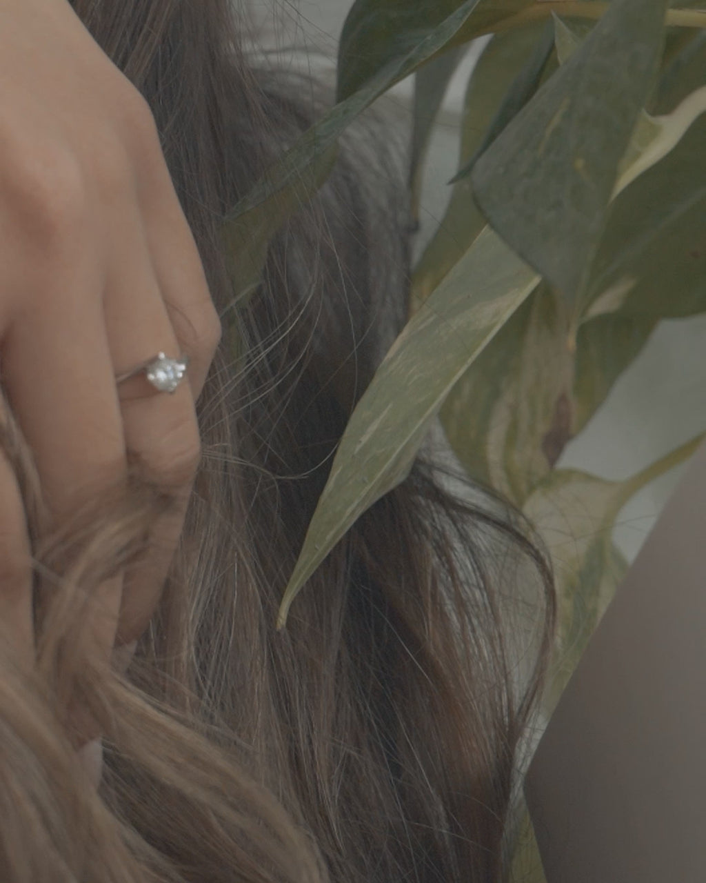 Λευκόχρυσο μονόπετρο δαχτυλίδι με διαμάντι και καστόνι σε σχήμα φλόγας, φορεμένο σε γυναικείο χέρι.
