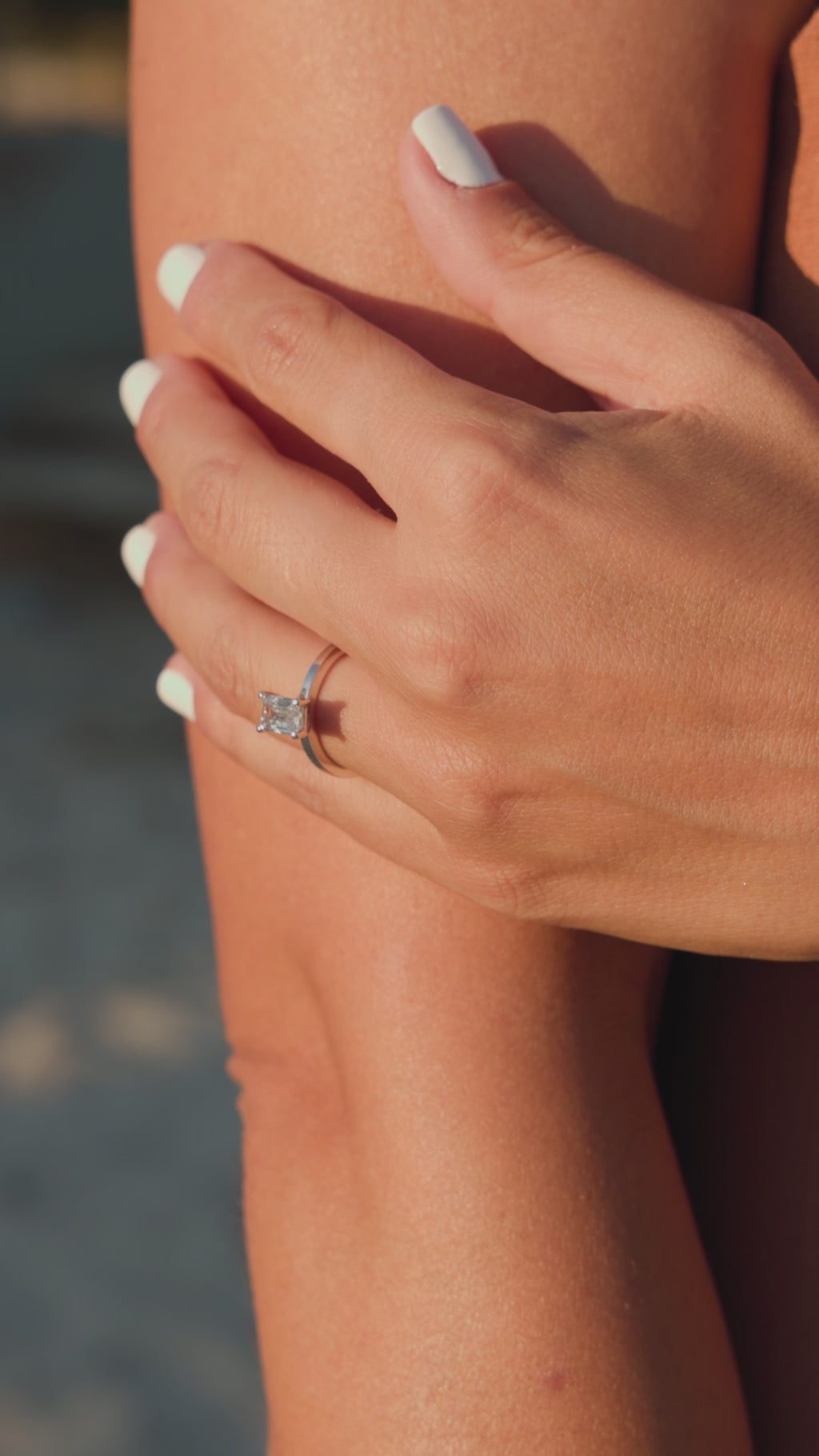 Λευκόχρυσο μονόπετρο δαχτυλίδι με διαμάντι σε τετράγωνο σχήμα baguette, φορεμένο σε γυναικείο χέρι.
