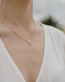 Γυναικείο χρυσό κολιέ 14Κ με καρδιά, κορώνα και ζιργκόν NL019 φορεμένο.