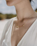 Γυναικείο χρυσό κολιέ 9Κ με ματάκι και σταυρό NL024 φορεμένο.