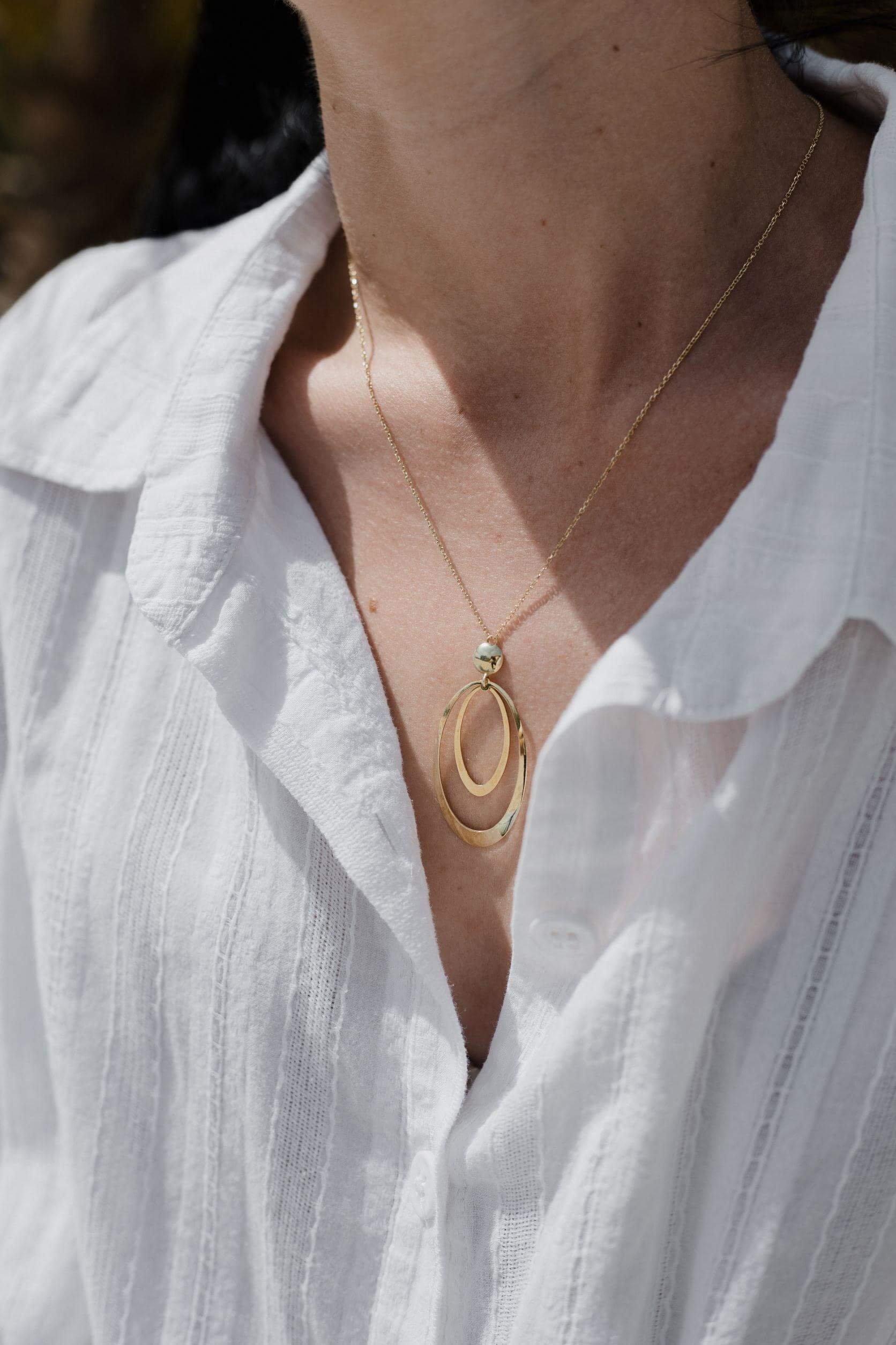 Γυναικείο χρυσό κολιέ Κ14 Themelidis Jewels NL103 με οβάλ στοιχεία φορεμένο.