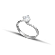 Λευκόχρυσο μονόπετρο δαχτυλίδι με διαμάντι και καστόνι σε σχήμα φλόγας, φορεμένο σε γυναικείο χέρι.