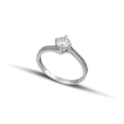 Λευκόχρυσο μονόπετρο με διαμάντι και καστόνι σε σχήμα φλόγας, διακοσμημένο με πλαϊνές πέτρες από μικρότερα διαμάντια., φορεμένο σε γυναικείο χέρι.