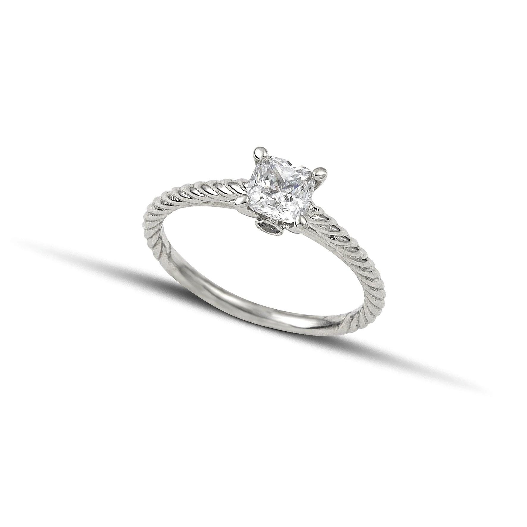 Μονόπετρο δαχτυλίδι με διαμάντι κατασκευασμένο από λευκόχρυσο με ανάγλυφες λεπτομέρειες στα πλαίνά μέρη του δαχτυλιδιού και καστόνι με τέσσερα δόντια.