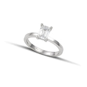 Λευκόχρυσο μονόπετρο δαχτυλίδι με διαμάντι σε τετράγωνο σχήμα baguette, φορεμένο σε γυναικείο χέρι.