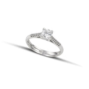 Λευκόχρυσο μονόπετρο δαχτυλίδι με διαμάντι και πλαίνές πέτρες από μικρότερα διαμάντια, φορεμένο σε γυναικείο χέρι.