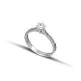 Μονόπετρο δαχτυλίδι γάμου με διαμάντι και πλαϊνές πέτρες brilliant κατασκευασμένο από λευκόχρυσο.