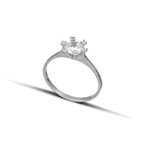 Μονόπετρο δαχτυλίδι γάμου με κεντρικό διαμάντι και πέτρες brilliant περιμετρικά κατασκευασμένο από λευκόχρυσο.