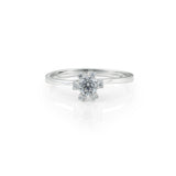 Μονόπετρο δαχτυλίδι γάμου με κεντρικό διαμάντι και πέτρες brilliant περιμετρικά κατασκευασμένο από λευκόχρυσο.