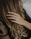 Φωτογραφία σε γυναικείο χέρι του μονόπετρου δαχτυλιδιού OS012 από λευκόχρυσο 14Κ με ζιργκόν, με πλαϊνές πέτρες και κομψή λάμψη για πρόταση γάμου ή αρραβώνα.