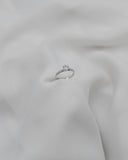 Φωτογραφία μονόπετρου δαχτυλιδιού OS010 από λευκόχρυσο 14Κ με ζιργκόν κατά μήκος της γάμπας, με κομψή λάμψη σε λευκό φόντο