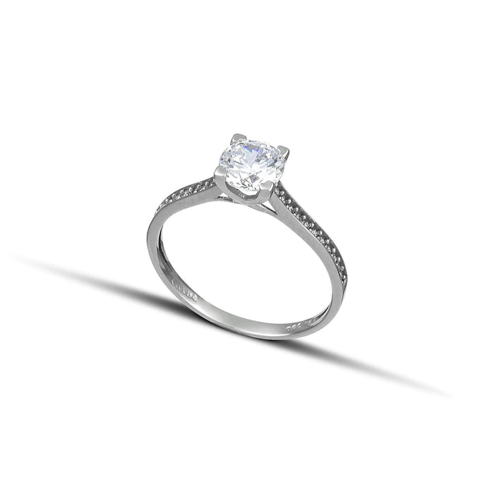 Λευκόχρυσο μονόπετρο με διαμάντι και πλαϊνές πέτρες από μικρότερα διαμάντια.