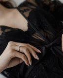 Λευκόχρυσο μονόπετρο με διαμάντι και δέσιμο φλόγας φορεμένο σε γυναικείο χέρι.