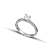 Λευκόχρυσο μονόπετρο με διαμάντι και καστόνι σχήματος V, φορεμένο σε γυναικείο χέρι.
