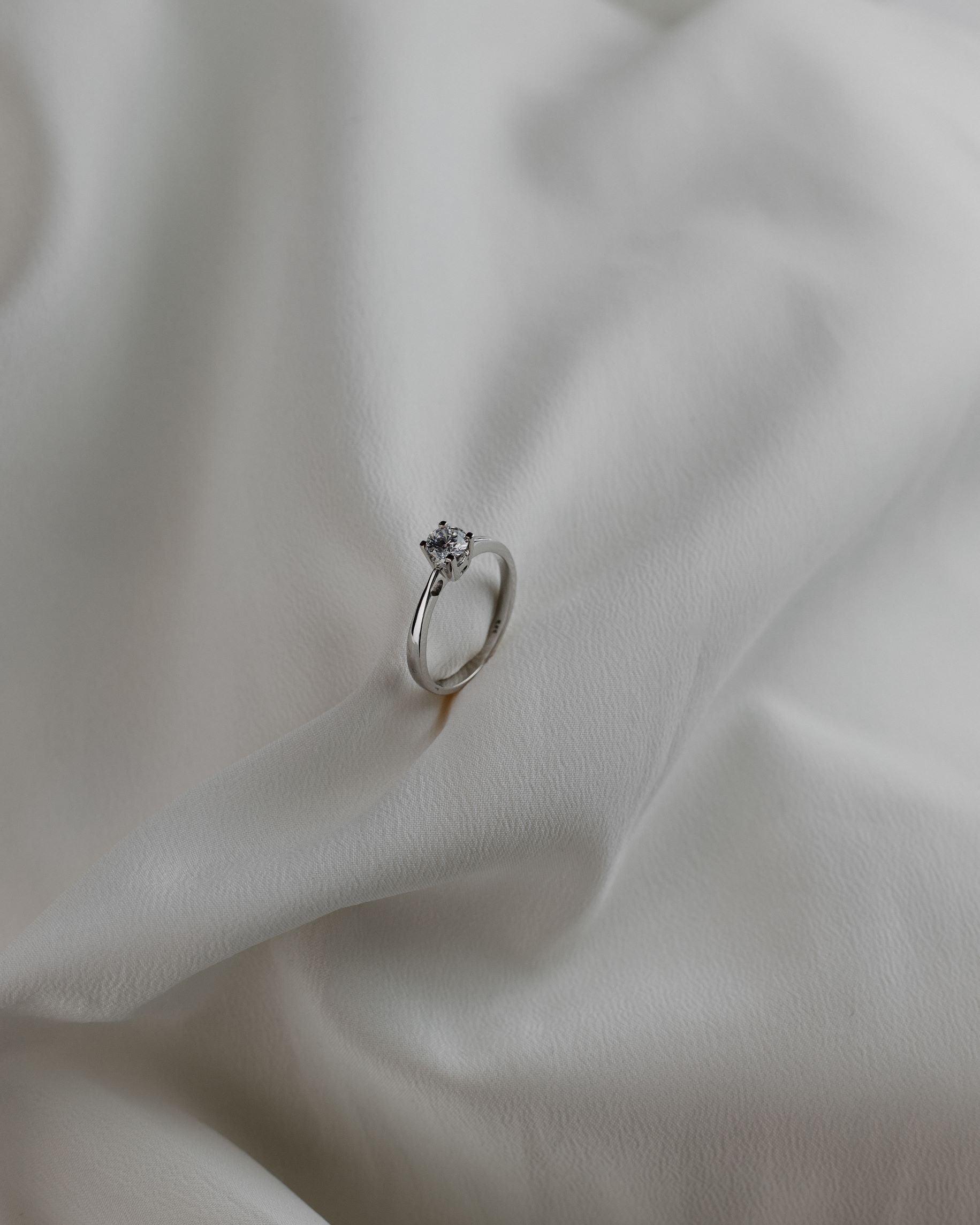 Λευκόχρυσο μονόπετρο με διαμάντι σε καστόνι σχήματος "V" και λεπτομέρεια καρδιάς.