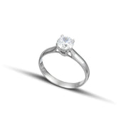 Λευκόχρυσο μονόπετρο δαχτυλίδι με διαμάντι φορεμένο σε γυναικείο χέρι.