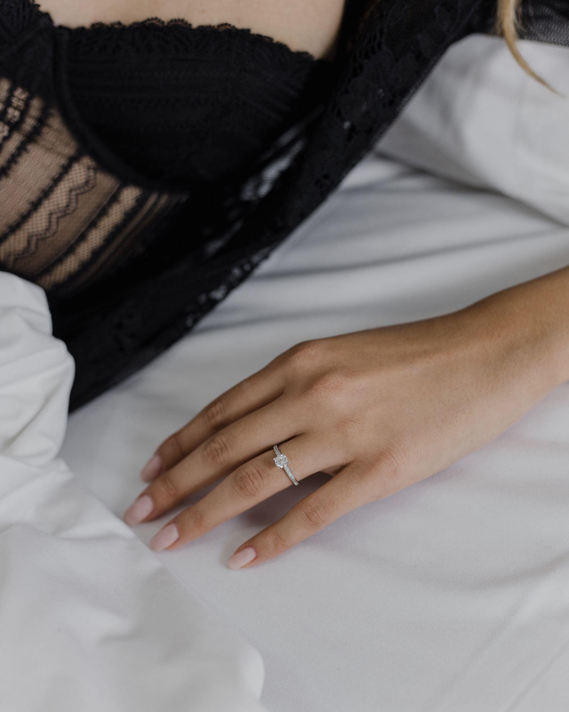 μονόπετρο δαχτυλίδι με διαμάντι και πλαϊνές πέτρες φορεμένο σε γυναικείο χέρι