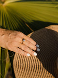 Ένα μονόπετρο δαχτυλίδι γάμου με διαμάντι κατασκευασμένο από λευκόχρυσο, με καστόνι από τέσσερα δόντια, φορεμένο σε γυναικείο χέρι.